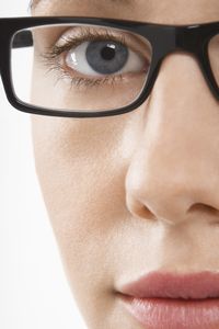 Egy nő, aki multifokális szemüveglencsét használ egy közeli felvételen.