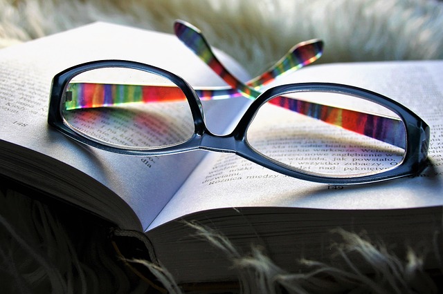 Nyitott könyvön nyugvó multifokális szemüveglencse.