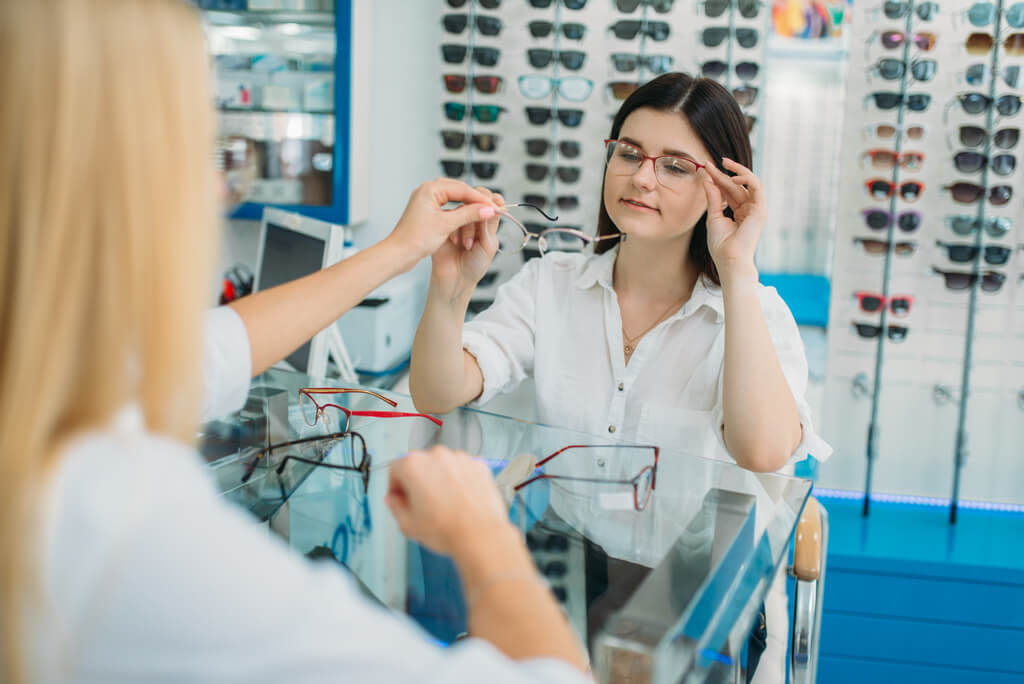 Igényes nő szemüvegeket próbál az optikában